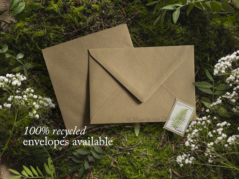 May include: Two brown paper envelopes with a green fern stamp on one of them. The envelopes are lying on a bed of green moss and white flowers. The text "100% recycled envelopes available" is printed below the envelopes.