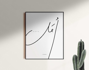 May include: Black framed art print with the word "HOPE" and Arabic calligraphy in black on a white background. The minimalist design features a single continuous line forming the Arabic script and the word "HOPE".
