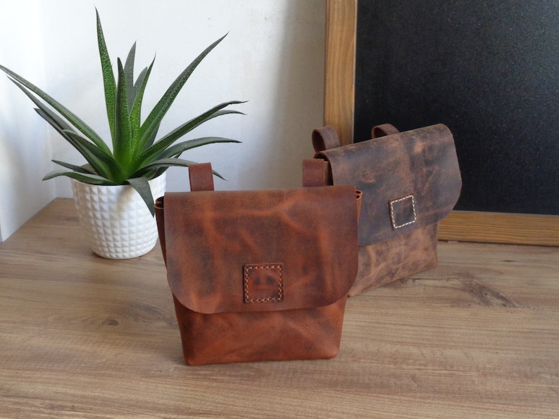 Peut inclure: Deux sacs en cuir marron avec des sangles r&eacute;glables et une fermeture &agrave; rabat. Les sacs ont un aspect vieilli et sont faits d'un cuir &eacute;pais et r&eacute;sistant.