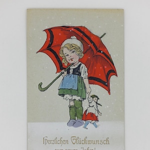 Ragazza sulla neve con bambola, cartolina antica, circa 1910