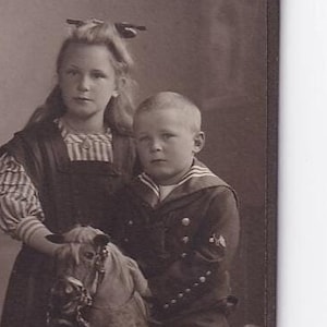 Junge auf grossem Spielzeugpferd reitend neben Mädchen, deutsches Visitfoto (Atelier Hüseler, Heinr. Petersen, Schleswig)