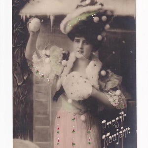 Femme avec chapeau et boules de neige devant la maison, carte postale autrichienne ancienne, envoyée en 1909