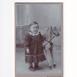 Uśmiechnięte dziecko z zabawkowym koniem, szwajcarskie zdjęcie Visitfoto (Friedrich Jaeggi, Langnau)