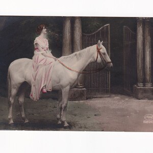 Kobieta na białym koniu przed bramą parku, niemiecka pocztówka, 1925 rok