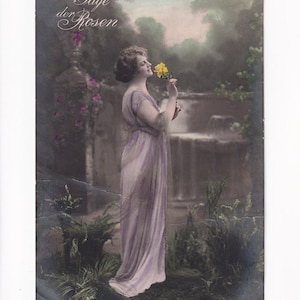 Mujer enamorada con un vestido de tul color baya frente a un parque, postal alemana antigua