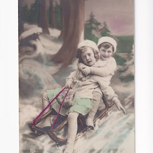 Niña y niño en trineo, postal alemana antigua