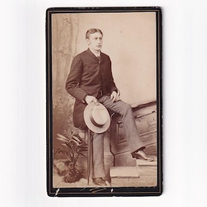 Man with straw hat and striped trousers on stair railing, Swiss Visitfoto (Francis de Jongh, Lausanne)