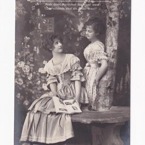 Sœurs avec un livre sur un banc rond sous un arbre, carte postale allemande ancienne