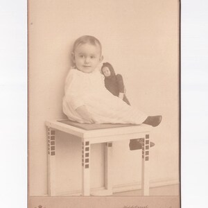 Bambino con maglietta e bambola con cappuccio, foto del gabinetto polacco (Udo Mertens, Poznan)