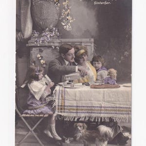 Familie am Gartentisch mit Hund und Puppe, antike deutsche Postkarte, 1918 geschrieben