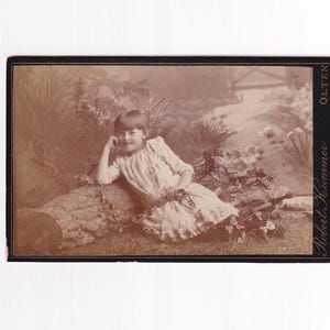 Lachend meisje zittend op een boomstam in een weide, Zwitserse Visitfoto (Robert Kummer, Olten)