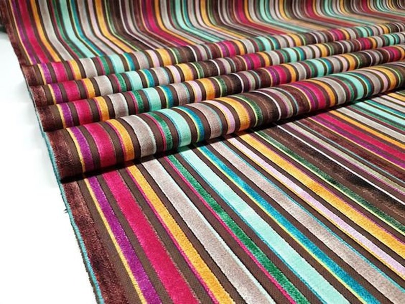 Puede incluir: Tela rayada multicolor con textura de terciopelo. La tela presenta una variedad de colores, incluyendo marr&oacute;n, rojo, amarillo, verde y azul.