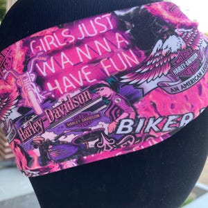 Könnte beinhalten: Ein pink-lila Biker-Stirnband mit dem Text "GIRLS JUST WANNA HAVE FUN" und Harley-Davidson-Logos. Das Design beinhaltet Motorradbilder und einen Adler, was eine kühne und energiegeladene Ästhetik erzeugt.