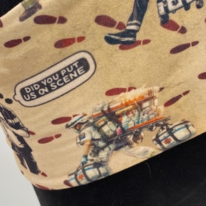 May include: A beige fabric with a repeating pattern of red footprints and illustrations of people in medical uniforms. The text "Did you put us on scene" is printed in a speech bubble.