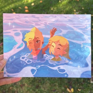 Op de afbeelding: Een rechthoekige kunstdruk met twee stripfiguren in een blauwe en witte oceaanscène. De personages hebben blond haar en lachen. Het kunstwerk heeft een zacht, pastelkleurig kleurenpalet met sprankelende accenten.