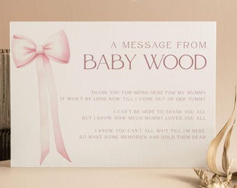 May include: A greeting card with a pink bow and the text "A MESSAGE FROM BABY WOOD" is displayed next to a lit candle in a ribbed glass holder. The card includes a message about a baby. The words "FULL & LOVE" are at the top.