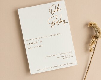 May include: A white baby shower invitation with gold lettering. The invitation reads "Oh Baby" and includes the details of the event: Aimee's Baby Shower, Sunday 26th October 2023, The Fic & Olive Middleton, Please RSVP to Lesley 079871638393. The invitation is signed "Full & Love".