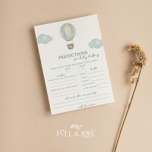 May include: A white baby shower prediction card featuring a watercolor illustration of a blue and beige hot air balloon with clouds. The text includes PREDICTIONS for baby halling, WHO WILL BABY HALLING LOOK LIKE, wishes, and birth details.