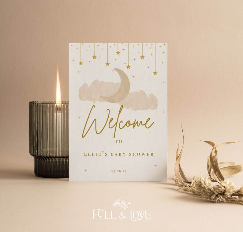 K&ouml;nnte beinhalten: Eine wei&szlig;e Karte mit goldener Schrift und einer Aquarell-Illustration eines Halbmondes und Wolken. Der Text lautet "Willkommen zu Ellies Baby Shower 25.06.23".