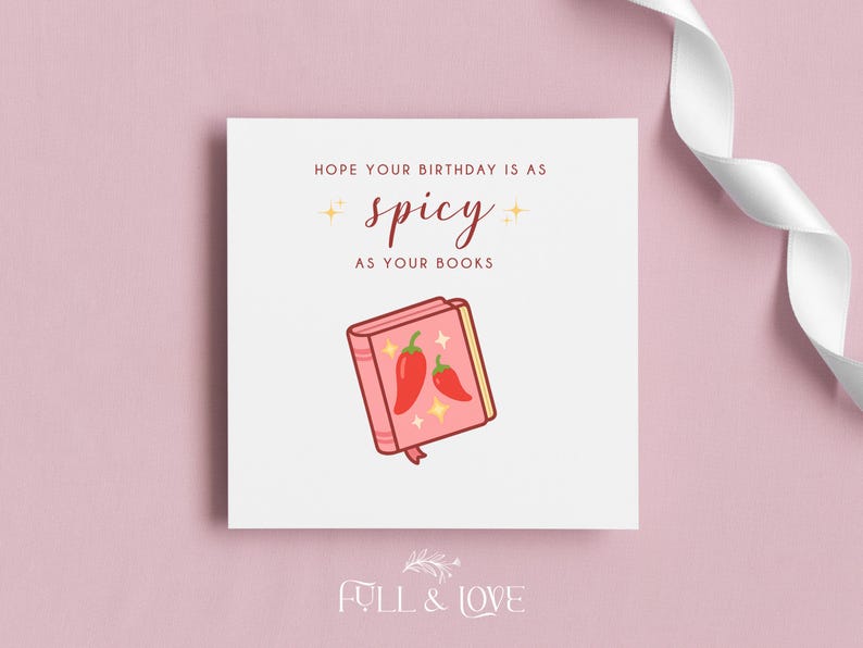 May include: A square greeting card with the text "Hope your birthday is as spicy as your books." The card features an illustration of a pink book with two red chili peppers. A white ribbon is in the background.