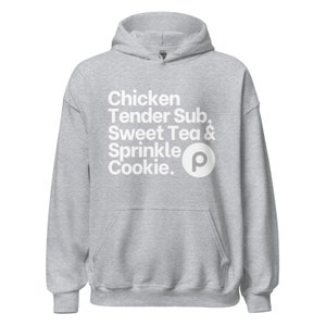 Puede incluir: Una sudadera con capucha gris con texto blanco que dice "Chicken Tender Sub, Sweet Tea & Sprinkle Cookie." Una letra "P" blanca está al lado del texto.