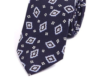 May include: A navy blue patterned tie with a white and light blue geometric design.