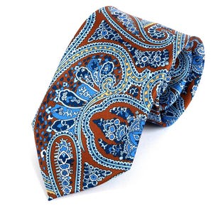 May include: A paisley patterned tie in shades of brown, blue, and yellow. The tie is made of a smooth fabric, suitable for formal or business wear. The design features intricate floral and teardrop shapes.