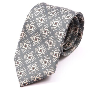 May include: A grey patterned tie with a white and brown geometric design.