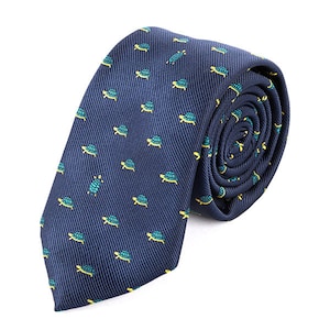 May include: A dark blue necktie with a repeating pattern of green and yellow turtles.