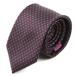 May include: Rolled burgundy tie with a repeating pattern of small blue and yellow floral designs. The tie is made of a textured fabric and has a purple label on the back.