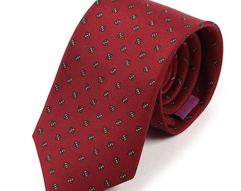 May include: A red patterned tie with a small, repeating design of blue and orange flowers. The tie is made of a smooth, silky fabric.