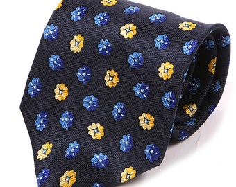May include: A navy blue silk tie with a repeating pattern of small yellow and blue flowers. The tie has a herringbone pattern.