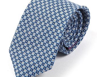 May include: A blue patterned tie with a small, repeating geometric design in shades of blue and gold.