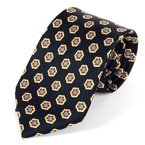 May include: A rolled navy tie featuring a repeating pattern of yellow, red, and light blue floral designs. The tie is made of a smooth fabric, suitable for formal or business wear.
