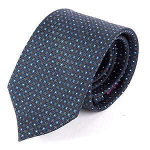 May include: A grey patterned silk tie with blue, white and orange geometric shapes. The tie is folded and tied in a knot.