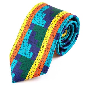 May include: A colourful tie featuring a repeating pattern of the periodic table of elements. The tie is made from woven fabric and has a blue, green, yellow, orange and red colour scheme.