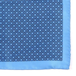 Puede incluir: Un pañuelo de bolsillo azul y blanco con un patrón y un borde azul sólido.
