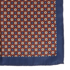 May include: A brown silk pocket square with a navy blue border and a repeating pattern of small white and blue squares.