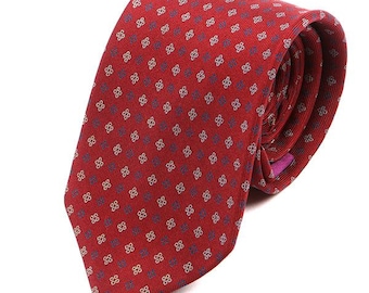 May include: A red patterned tie with a small white and blue design. The tie is made of silk and has a classic design.