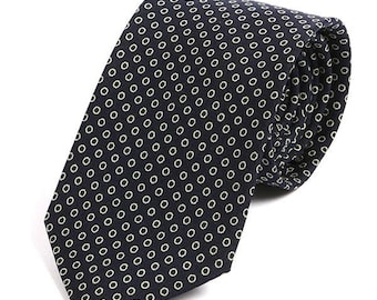 May include: A dark blue necktie with a repeating pattern of small, light green circles.
