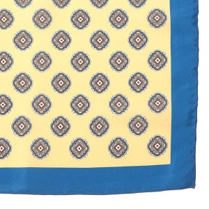Puede incluir: Un pañuelo de bolsillo amarillo con un borde azul y un patrón repetitivo de pequeños diseños geométricos azules y rojos.