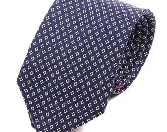 May include: A navy blue tie with a white floral pattern.