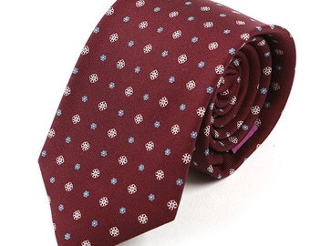 May include: A burgundy necktie with a white and blue floral pattern.