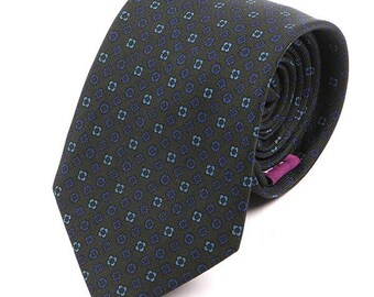 May include: A dark green patterned tie with a blue and light blue geometric design. The tie is rolled up and has a pink tag.