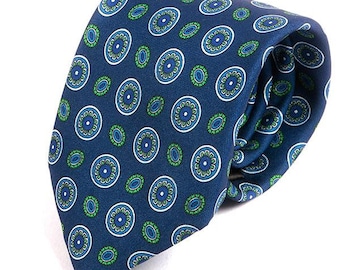 May include: A blue silk tie with a repeating pattern of green and white circles.