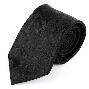 May include: A black paisley patterned tie. The tie is rolled up, displaying the detailed floral and curved patterns. The tie is made of a shiny material.