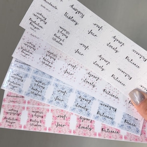 May include: A set of adhesive index tabs for journals or books, featuring various floral and speckled patterns in white, blue, and pink. Each tab is printed with black cursive text including words like History, Fear, Lonely, Patience, and Protection Prayer.