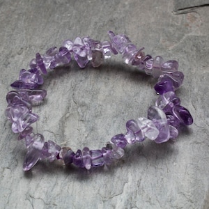 Könnte beinhalten: Ein violettes Amethyst-Chip-Armband aus kleinen, unregelmäßig geformten Steinen.