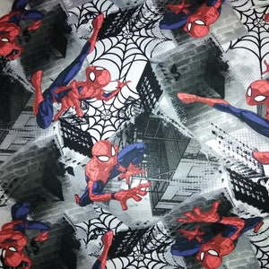 Może przedstawiać: Czarno-biała tkanina z powtarzającym się wzorem Spidermana huśtającego się w mieście. Tło stanowi szare miasto z białymi pajęczynami.