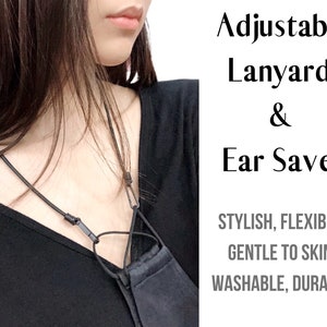 May include: A black adjustable lanyard with a black face mask attached. The lanyard is designed to be an ear saver, making it comfortable to wear a face mask for extended periods. The text on the image reads "Adjustable Lanyard & Ear Saver. STYLISH, FLEXIBLE, GENTLE TO SKIN, WASHABLE, DURABLE."